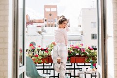 beautiful-girl-from-back-pajamas-balcony-sunny-morning-she-raises-leg-looks-excited-camera